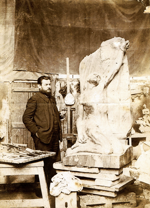 Armand Bloch dans son atelier posant près de sa sculpture